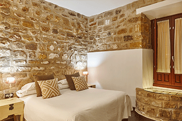 bedroom-with-stone-walls-comfortable-modern-hotel-6TBGZCP.png